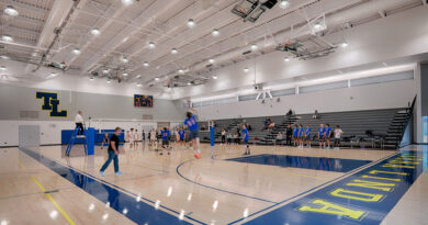 Terra Linda's Gymnasium interior. Hardwood floors with blue accents. High ceilings with bright white lights.