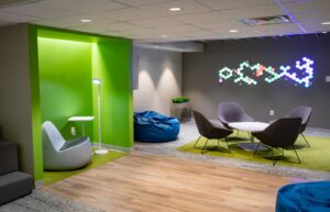 A student center featuring soft lighting, and a variety of comfortable seating areas including a bean bag, and low seating around a table.