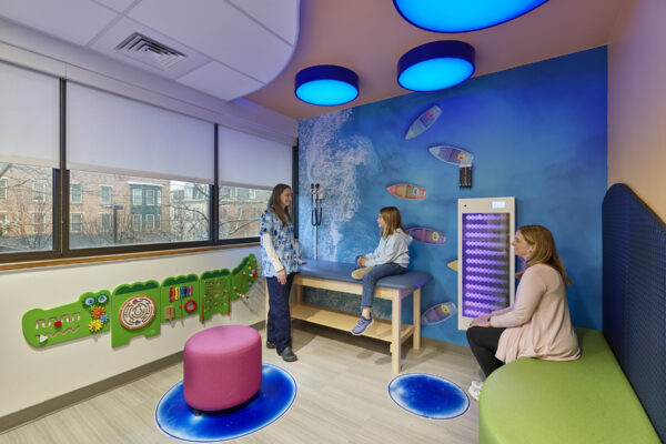 Wellness on a Budget: How sensory spaces can support the mental health of students and teachers Colorful wellness room with a calming mural of the ocean, large windows, and comfortable spaces to sit.