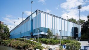 The Philip & Cheryl Milstein Family Tennis Center rises above the Hudson and Harlem Rivers, showcasing a vertical design that maximizes limited urban space while enhancing athletic performance.