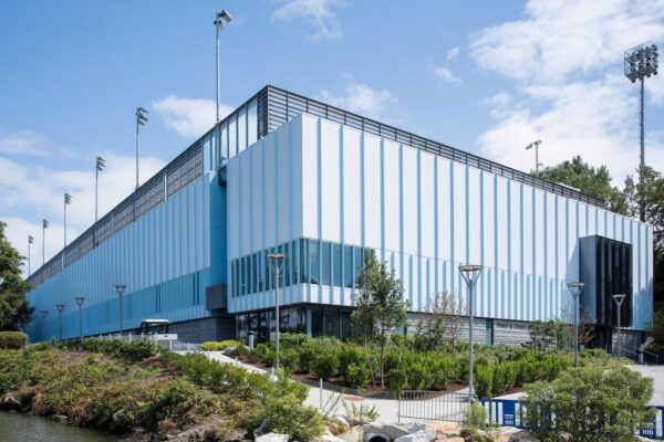 The Philip & Cheryl Milstein Family Tennis Center rises above the Hudson and Harlem Rivers, showcasing a vertical design that maximizes limited urban space while enhancing athletic performance.