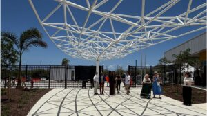 Shaded outdoor spaces, a central gathering area, and a gymnasium that doubles as a storm shelter support both everyday school life and community events.