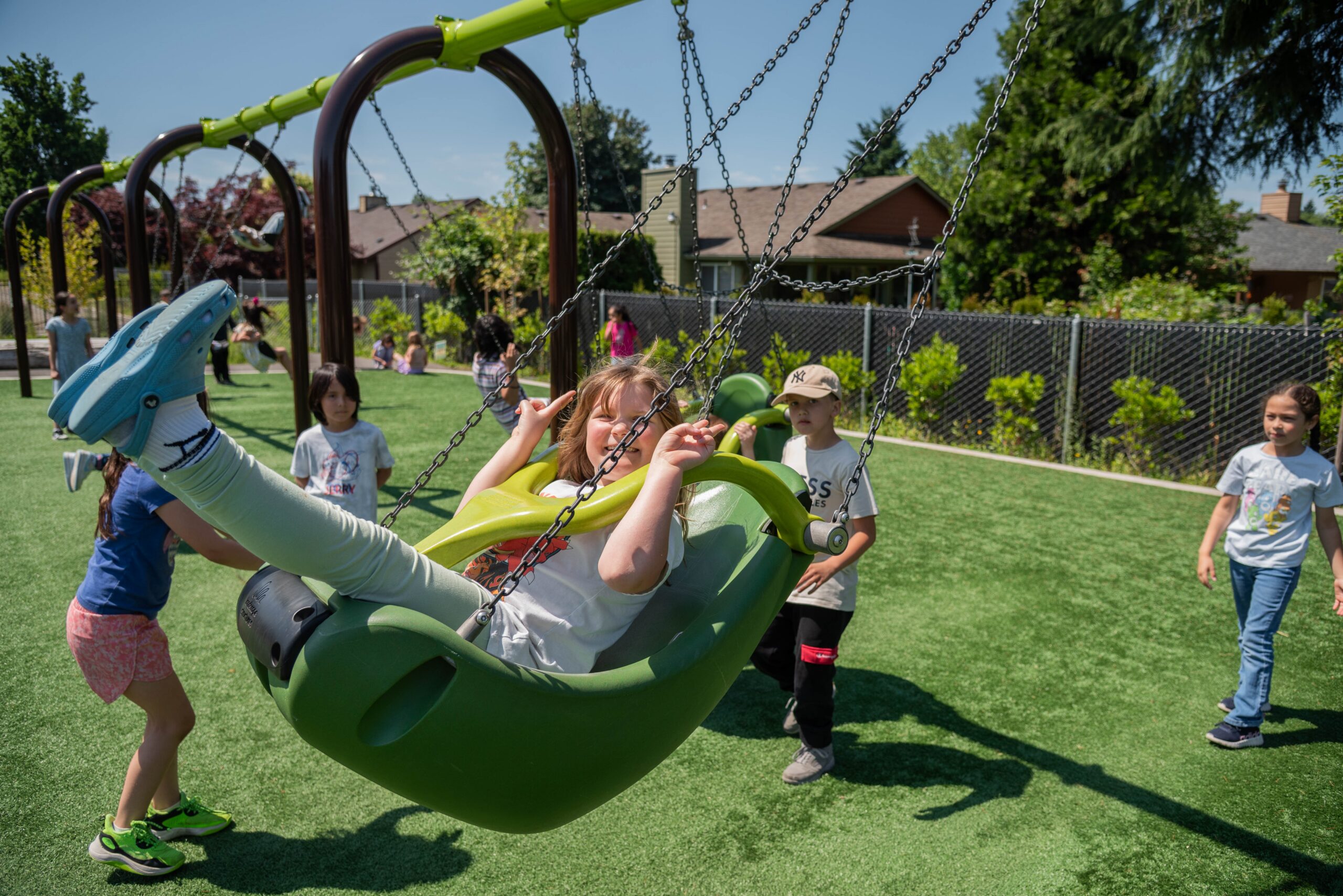 children playing on swings at an inclusive playground