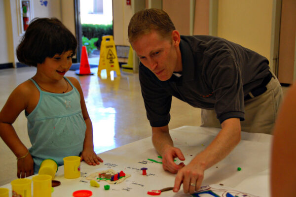 teacher and student exhibiting sensory play materials